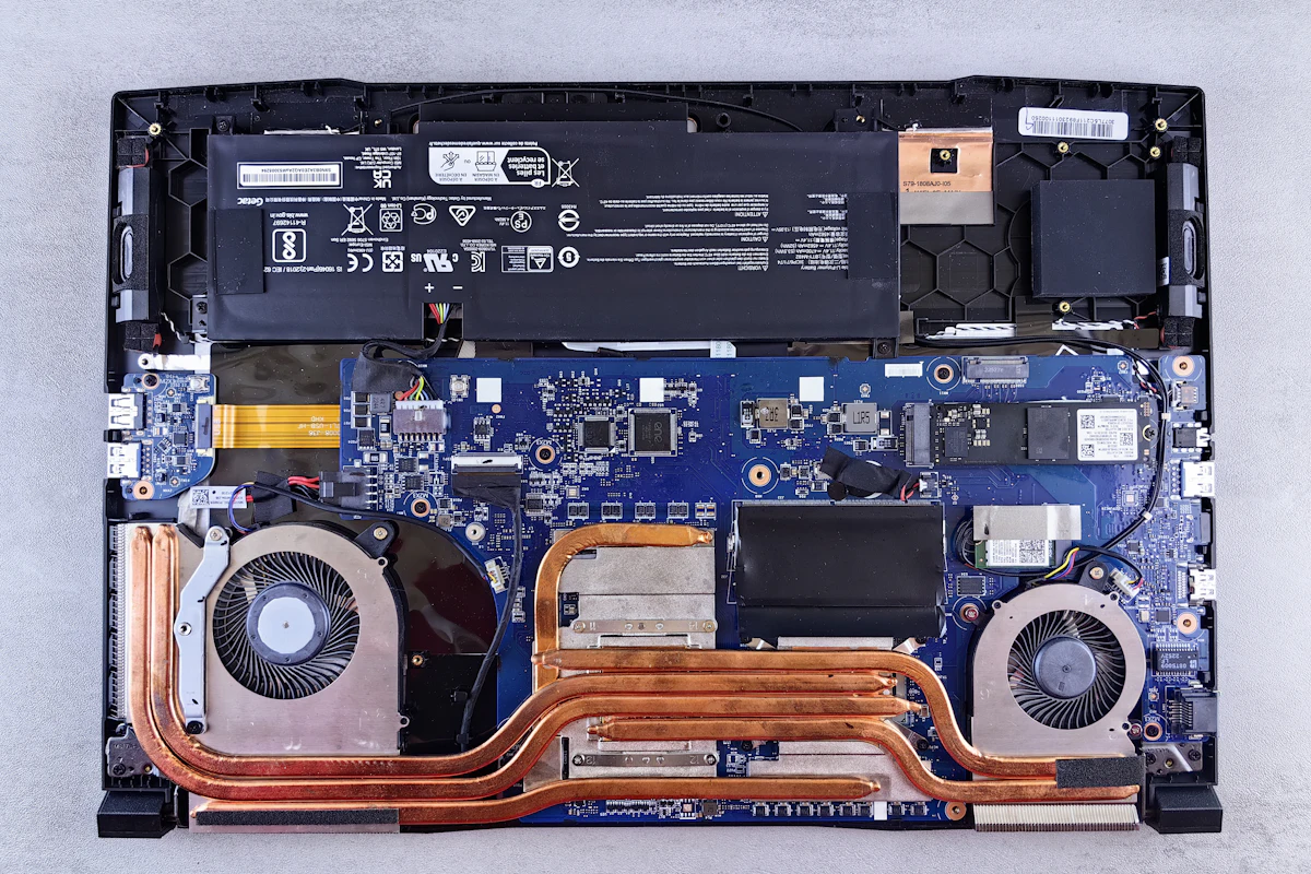 Geopende laptop met accu, moederbord, heatpipes en twee ventilatoren