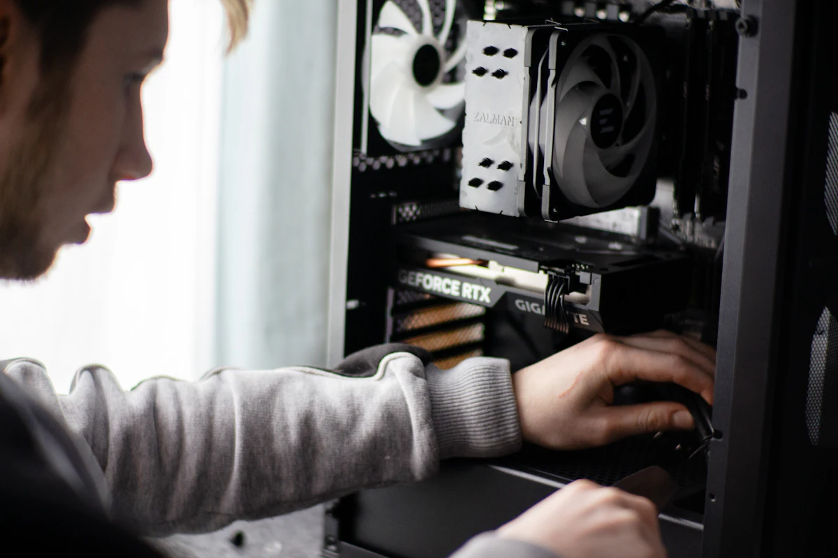 Iemand werkt aan de binnenkant van een geopende desktop-pc